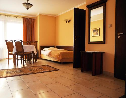 a bedroom with a bed and a table and chairs at Willa Koba in Ustroń
