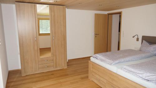 1 dormitorio con 1 cama y armario de madera en Haus Edeltraud en Mellau