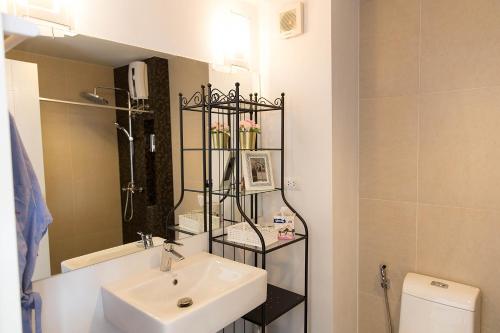 a bathroom with a sink and a mirror and a toilet at Mosaic CondominiumA62M by malai in Mae Pim