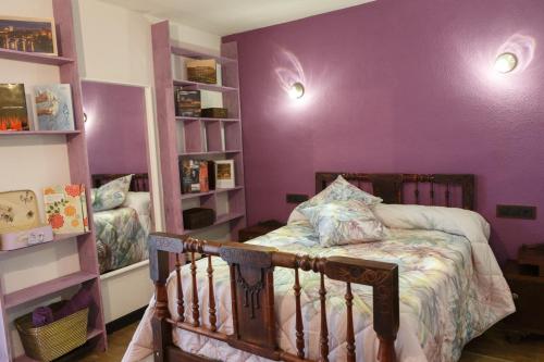 a bedroom with purple walls and a crib at Arcipreste in Zamora