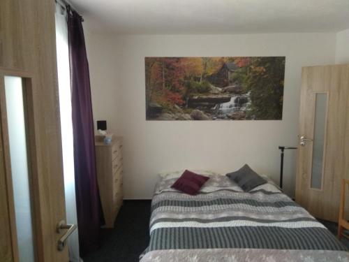 a bedroom with a bed and a painting on the wall at NOVODVORSKÝ APARTMÁN SÁRA in Nové Dvory