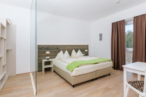 a bedroom with a bed and a glass wall at Villa Blumegg in Hermagor