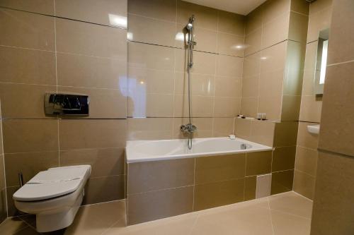 a bathroom with a toilet and a bath tub at Pine Woods Apartment A28 in Silver Mountain in Poiana Brasov