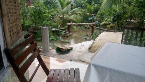 a table and chairs on a patio with a garden at mekong floating market Nam Giang homestay in Cai Be