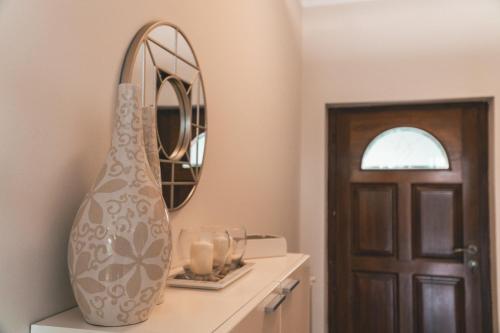 a vase sitting on a counter next to a mirror at Apartment Serenum in Matulji