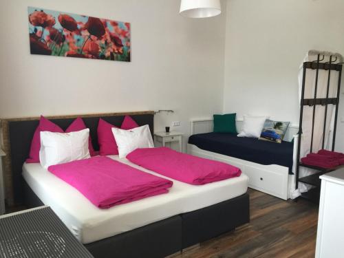 - une chambre avec 2 lits avec des draps roses dans l'établissement Candussi-Apartments, à Pörtschach am Wörthersee