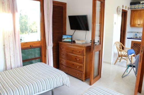 een slaapkamer met een bed en een televisie op een dressoir bij Villacana 2816 in Estepona