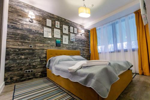 a bedroom with a bed and a wooden wall at Pine Woods Apartment A43 in Silver Mountain in Poiana Brasov