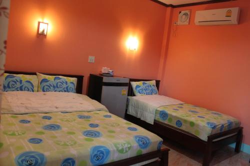 a small bedroom with two beds and a refrigerator at Lam-tong Resort in Don Sak