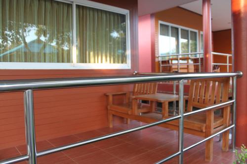 a balcony with two chairs and a window at Lam-tong Resort in Don Sak