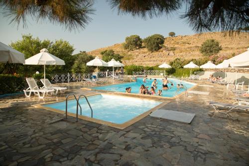 een groep mensen in een zwembad met parasols bij Akti Hotel & Apartments in Mithimna