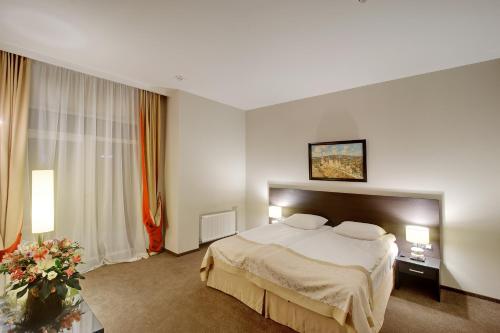 a hotel room with a bed and flowers in it at Optima Collection Troitska in Dnipro