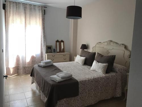 a bedroom with a bed with two towels on it at Apartamento Canela in Ayamonte