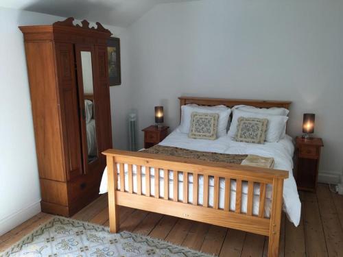 una camera da letto con un grande letto in legno con due lampade di Old Rectory - Scoulton a Great Ellingham