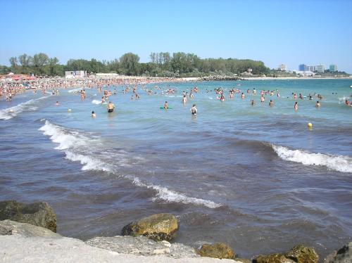 a group of people in the water at a beach at Apartament Onix in Neptun
