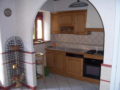 a kitchen with an archway in the middle of it at gite du navech in Camjac