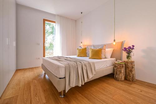ein Schlafzimmer mit einem großen weißen Bett mit gelben Kissen in der Unterkunft Casa Vari in Rovinj