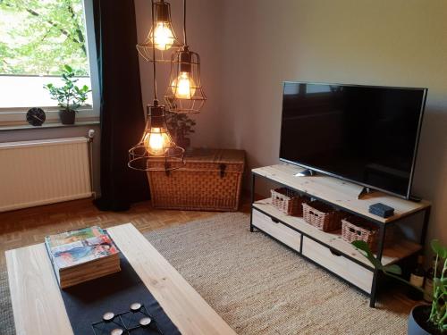 uma sala de estar com uma grande televisão de ecrã plano em Stylisch-gemütliche 70qm im zentralen D-Derendorf em Dusseldorf