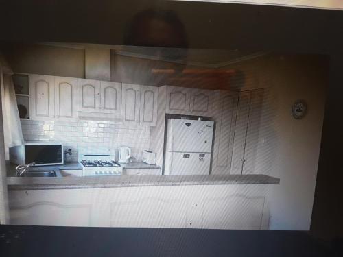 
a kitchen with a refrigerator and a microwave at Glenelg Shores in Adelaide
