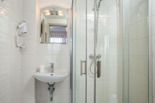 La salle de bains est pourvue d'un lavabo et d'une douche. dans l'établissement Anioł Morski, à Władysławowo