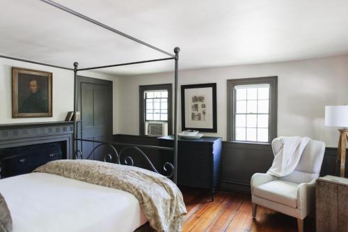 a bedroom with a bed and a chair at Squire Tarbox Inn in Westport