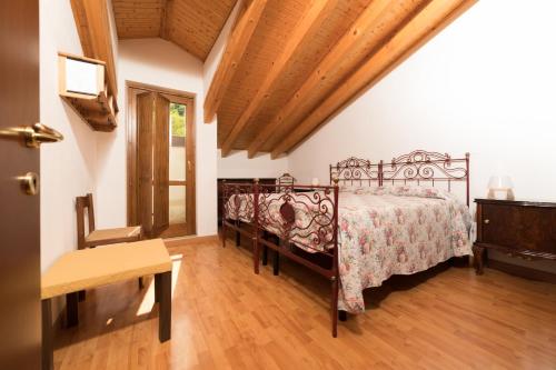 a bedroom with a bed and a wooden floor at Agriturismo Carovane in Compiano