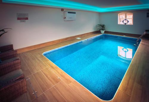 a large swimming pool in a room with at Woodspurge Cottage, Drift House Holiday Cottages in Astbury