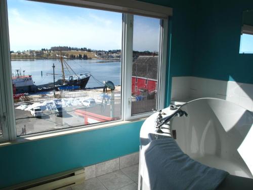 a bath tub in a room with a window at Brigantine Inn in Lunenburg