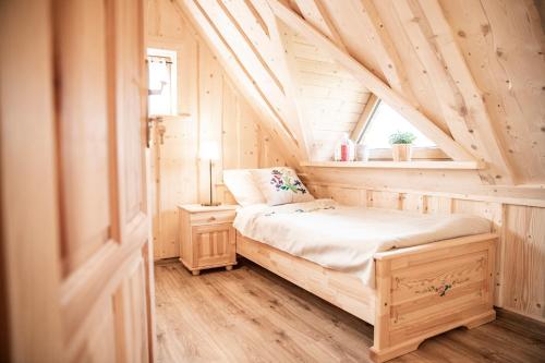 una piccola camera da letto con un letto in mansarda di Domek Folkowa Chata a Poronin