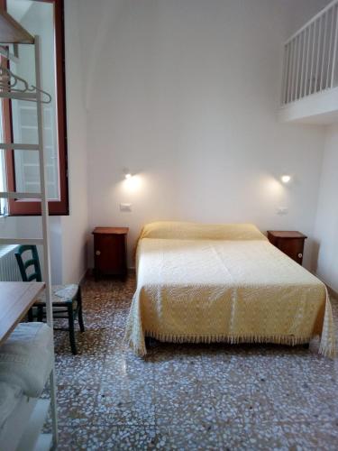 a bedroom with a bed and a chair and a ladder at Cortile Calinea in Castrignano del Capo