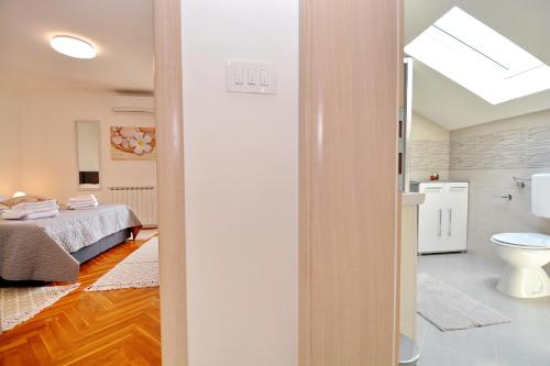 a bathroom with a bed and a toilet in a room at Villa Zupan in Zadar