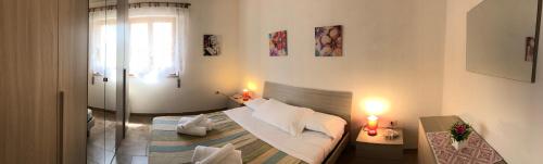 um quarto com uma cama, uma janela e 2 candeeiros em Appartamenti Abbaidda em Valledoria