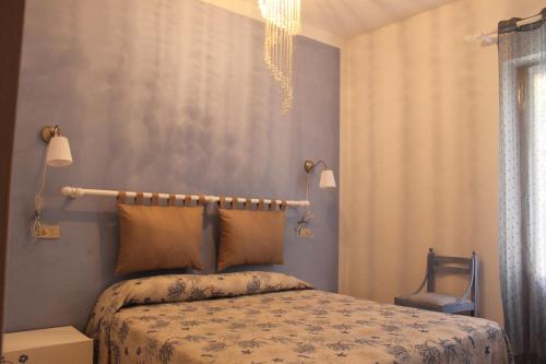 a bedroom with a bed and a chandelier at casa azzurra piano terra in Fetovaia