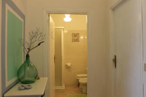 a bathroom with a green vase sitting on a table at casa azzurra piano terra in Fetovaia