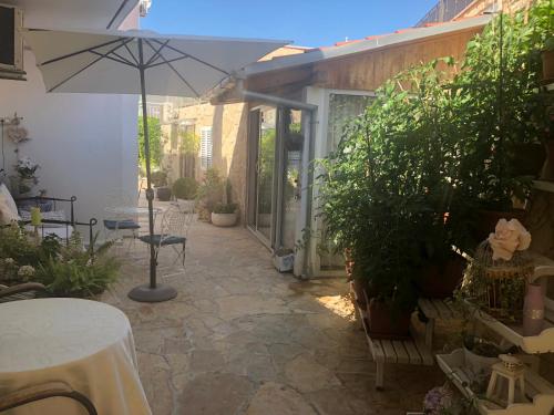 a patio with a table and an umbrella and plants at Casa di Lavanda in Hvar