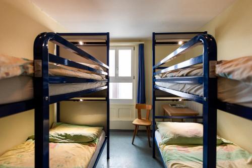 two bunk beds in a room with a window at Happy Inn Lodge in Interlaken