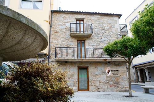 a building with a balcony on the side of it at A Bughina apartamentos in Muxia