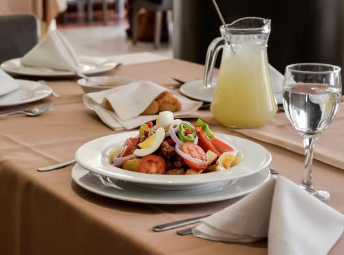 a table with a plate of food and a glass of milk at Gran Hotel Toloma in Cochabamba