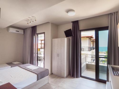 um quarto com uma cama e vista para o oceano em Afrodite Beach em Neoi Poroi