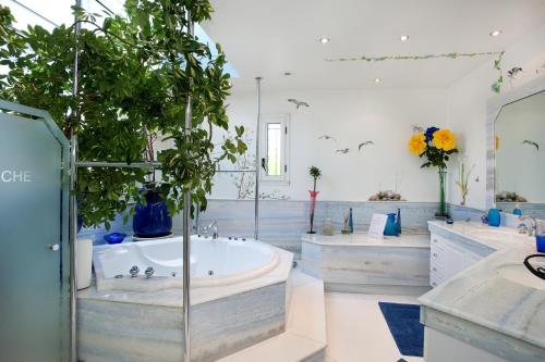 a bathroom with two sinks and a tub with plants at Le Domaine de Charline de 1 à 35 personnes in Issel