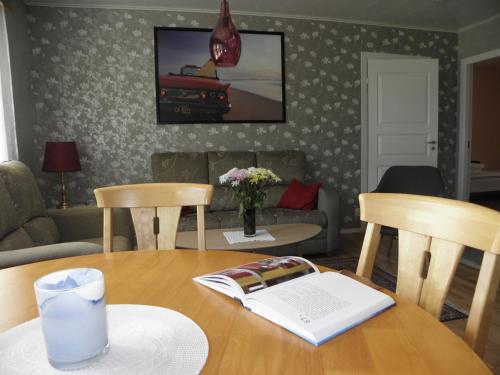 a living room with a table with a book on it at Söderö stugby in Finström