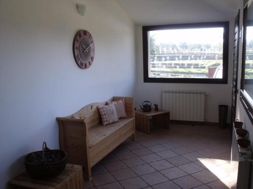 a living room with a couch and a clock on the wall at B&B Podere Montese in Villafranca in Lunigiana