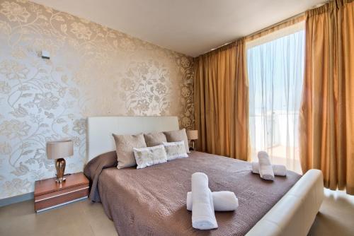 A bed or beds in a room at Magnificent Seafront 2-bedroom Sliema penthouse