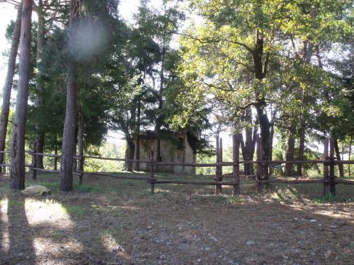 an old cabin in the woods next to a fence at B&B Podere Montese in Villafranca in Lunigiana