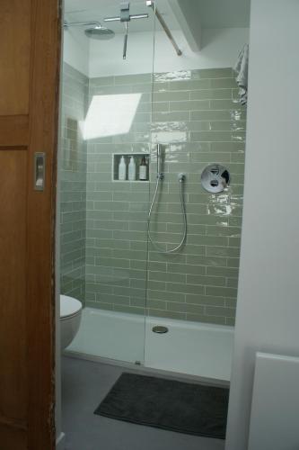 ein Bad mit einer Dusche und einer Glastür in der Unterkunft Sommarhus in Zandvoort