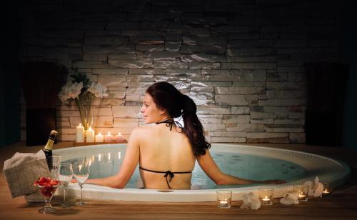 kobieta w wannie ze świecami i kieliszkami do wina w obiekcie Hotel Viest w mieście Vicenza