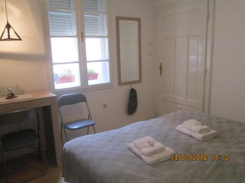 a bedroom with a bed with two towels on it at Kuća Popović Apartments in Niš