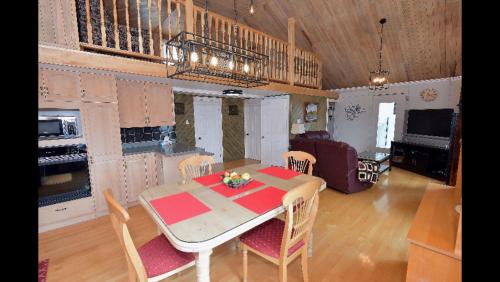 een keuken en eetkamer met een tafel en stoelen bij Paradis du Lac Nairne in Notre-Dame-des-Monts