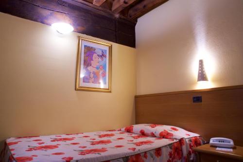 a bedroom with a bed and a picture on the wall at Hotel La Luna in Lucca