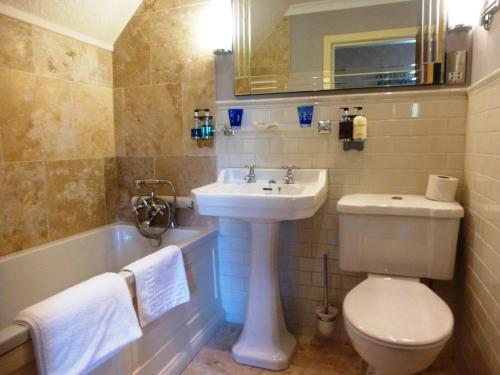 a bathroom with a sink and a toilet and a tub at Corriegour Lodge Hotel in Spean Bridge